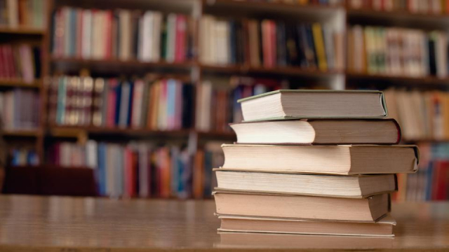 Books stacked on table in library